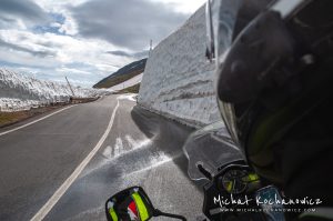 Riding through Alps by motorcycle, four meters of snow on the side of the road